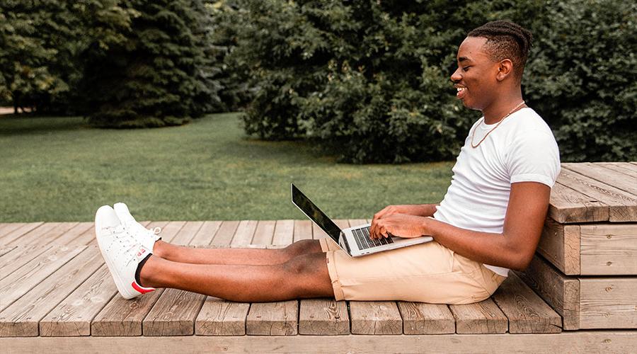 年轻的黑人男学生在笔记本电脑上查找转学资源